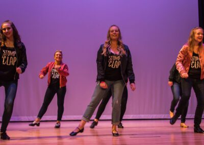 A lively performance by a group of young women dancing gracefully on a stage.